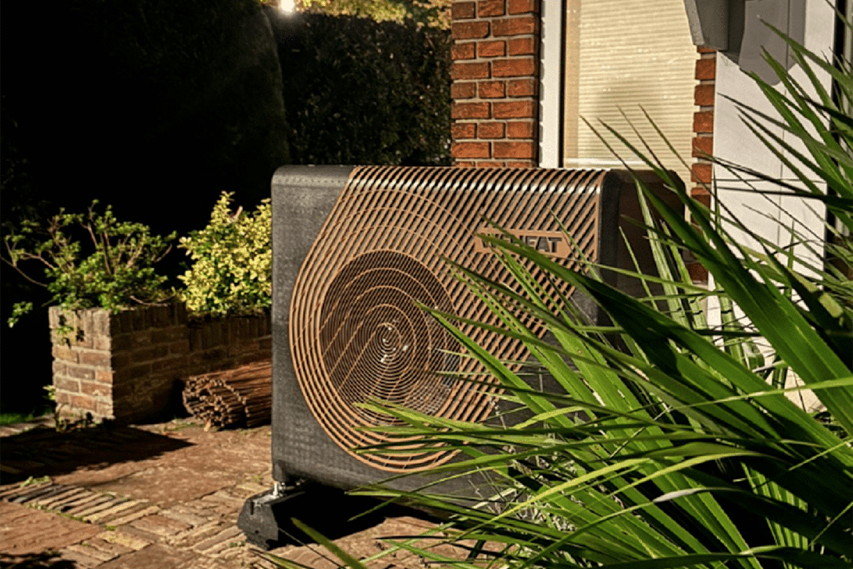 Geplaatste warmtepomp aan de gevel van een woning, avondopname
